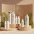 Haetsia luxury haircare collection displayed on natural wood podiums with tropical leaves, used for wholesale